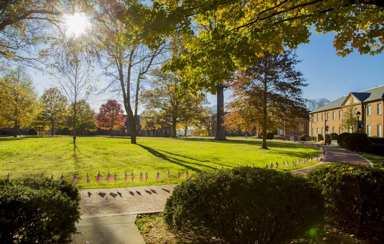 The King University quad in autumn, lined with flags