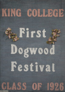A vintage-style sign reads “King College First Dogwood Festival Class of 1926” with pink flower decorations on a blue textured background.