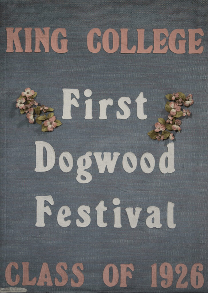 A vintage-style sign reads “King College First Dogwood Festival Class of 1926” with pink flower decorations on a blue textured background.